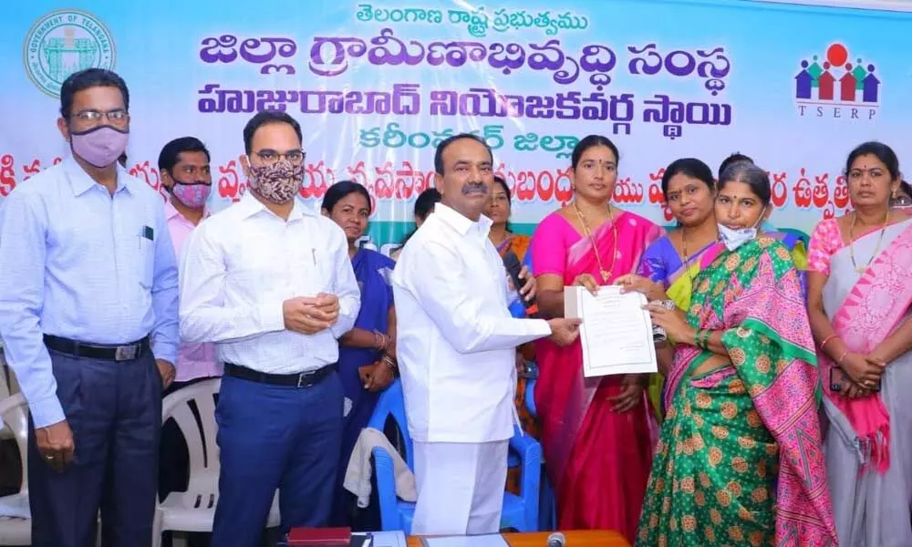 Health Minister Eatala Rajender presenting a cheque to a Self-Help Group member at a programme at his camp office in Huzurabad on Wednesday