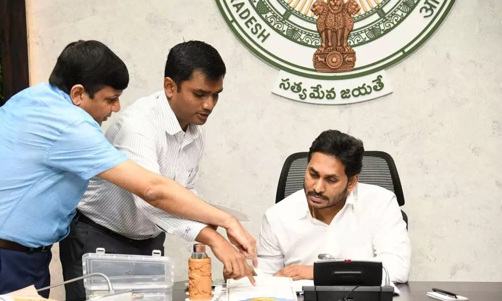 Chief Minister Y S Jagan Mohan Reddy examines the samples of awards and citations to be awarded to volunteers, at a review in his camp office on Wednesday