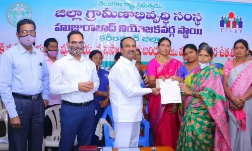 Health Minister Eatala Rajender presenting a cheque to a Self-Help Group member at a programme at his camp office in Huzurabad on Wednesday