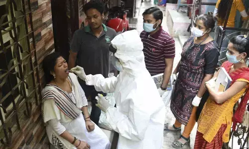 A health worker collects swab samples of the residents of Dharavi during a door-to-door screening for Covid-19, in Mumbai on Thursday