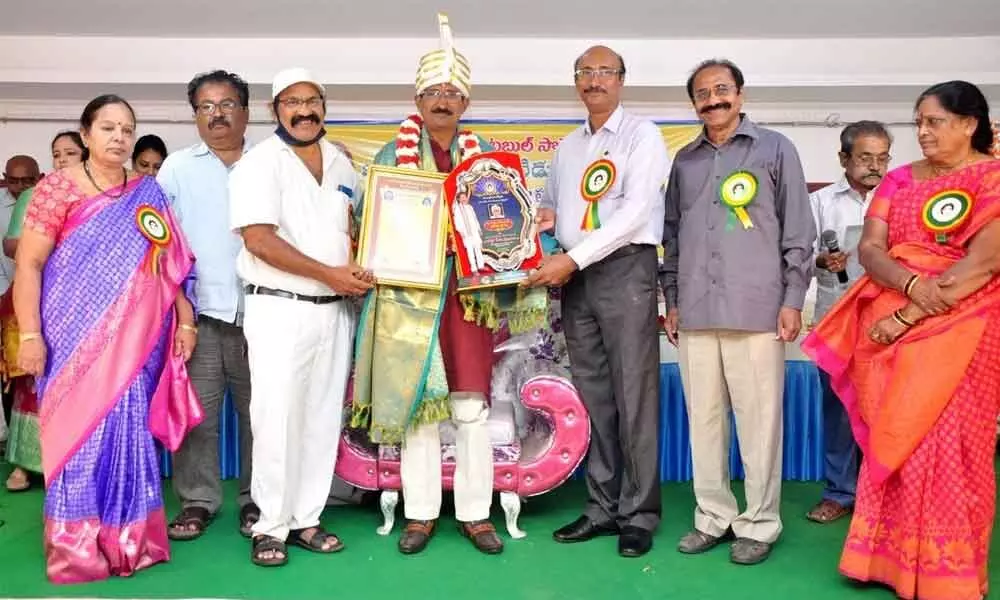 PraRaSam president Ponnuru Srinivasulu receiving Dr Nagabhairava Award from Ratnam Charitable Society members in Nellore on Saturday