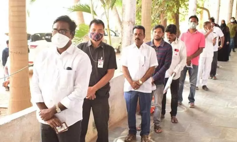 Transport Minister P Ajay Kumar standing in queue to cast his vote at SSRJ College in Khammam on Sunday