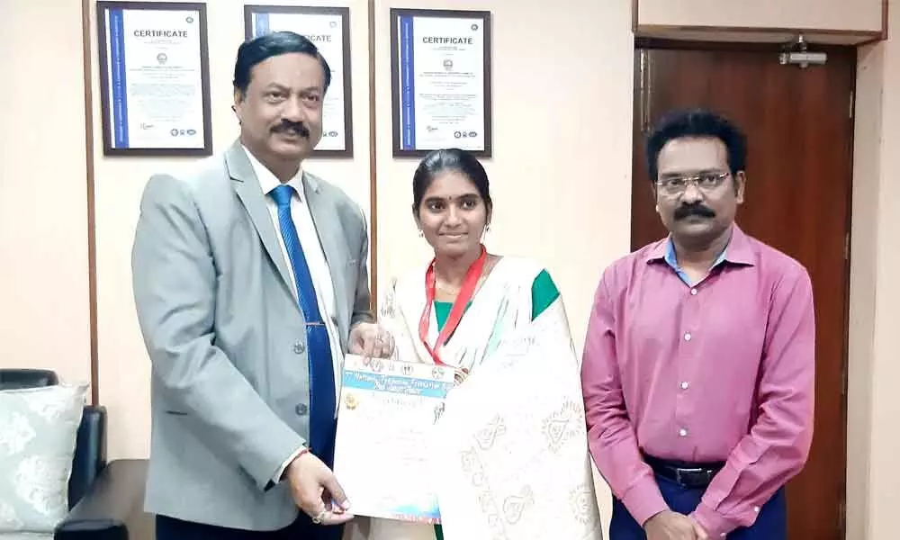 Adikavi Nannaya University VC professor Mokka Jagannadha Rao felicitating political science final year student A Tulasi who bagged gold medal in National Thai Boxing competition at his chamber