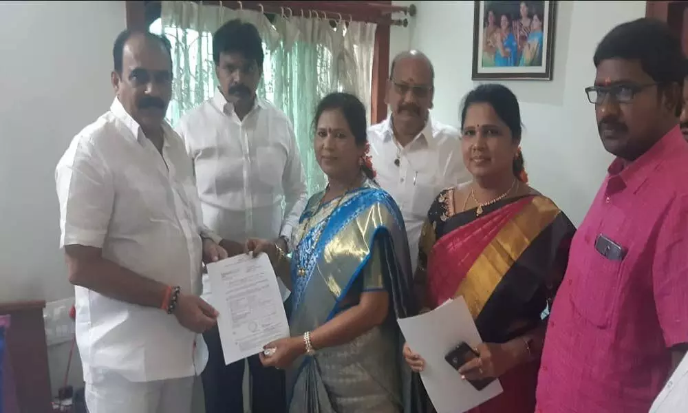 Minister Balineni Srinivasa Reddy handing over the form selecting Gangada Sujatha as the Mayor of Ongole Municipal Corporation, at his residence in Ongole on Thursday