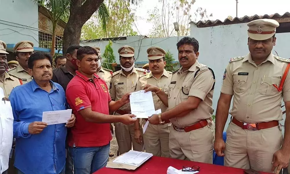 ACP Rama Rao giving away insurance bonds to home guards at a programme at ACP office in Bodhan on Friday