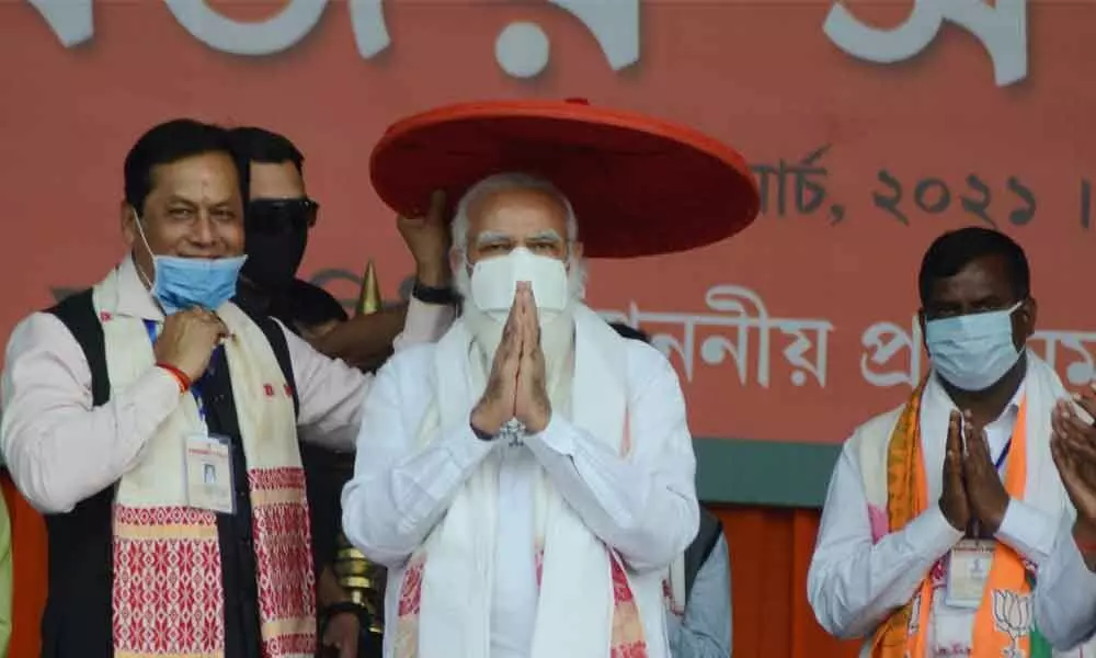 Prime Minister Narendra Modi being presented an ‘Assamese Japi’ by Assam Chief Minister Sarbananda Sonowal during a public rally ahead of Assam Assembly Polls