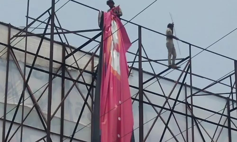 Poster being removed at Kankaragunta flyover in Guntur on Sunday