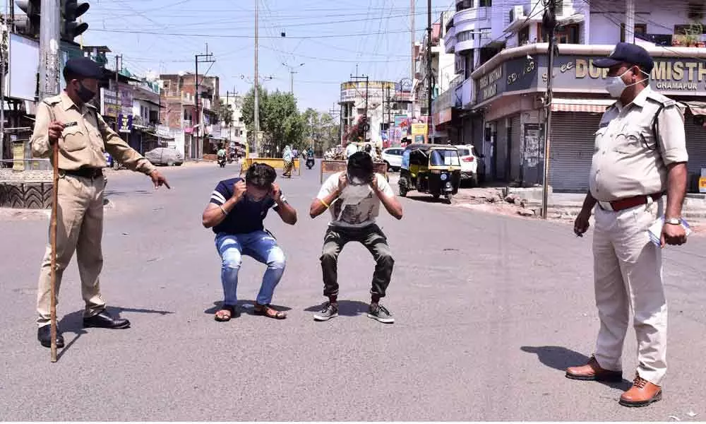 Police punish commuters for flouting lockdown norms, imposed by  authorities to curb the recent surge in coronavirus cases in Jabalpur on Sunday