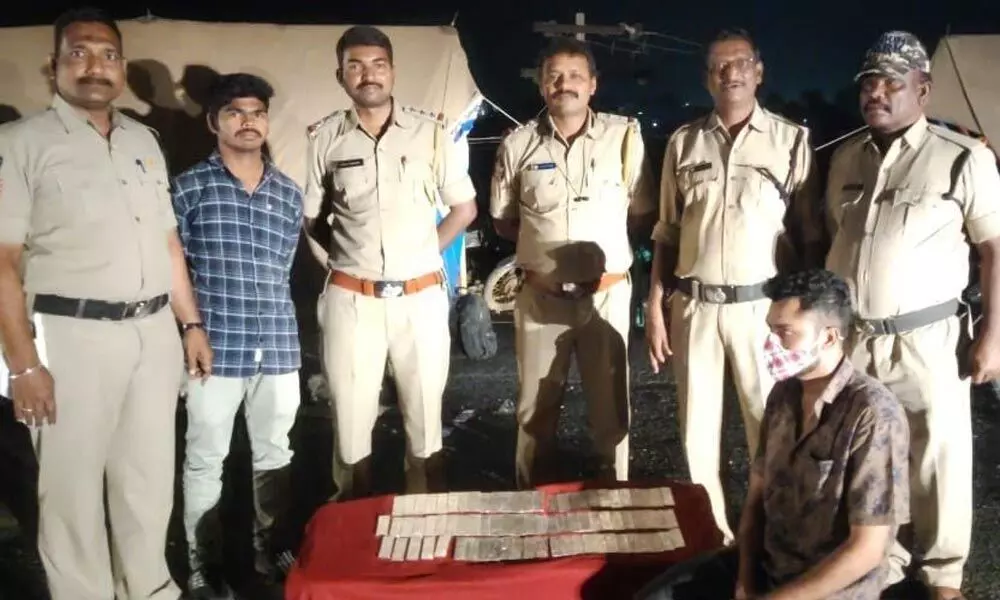 SEB Circle Inspector R Ravi Chandra and staff with the seized silver biscuits at Panchalingala border check-post in Kurnool district on Sunday evening