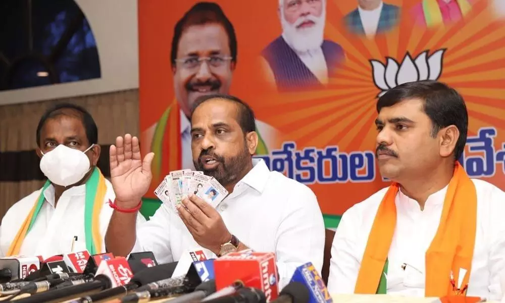 BJP national secretary Y Satyakumar showing the fake voter card at a media conference in Tirupati on Wednesday. BJP State chief Somu Veerraju is also seen