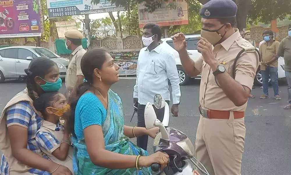 Guntur Urban SP RN Ammi Reddy counselling a vehicle rider for not wearing a mask in Guntur on Monday