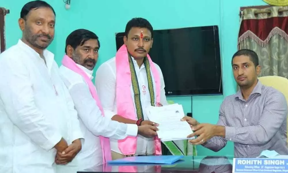 TRS candidate Nomula Bhagat Kumar submitting his nomination papers to Election Returning Officer Rohith Singh in Nidamanoor on Tuesday