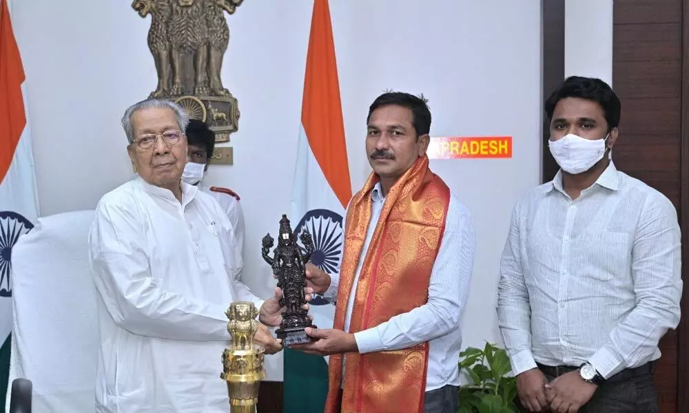 Governor Biswa Bhusan Harichandan felicitating junk artist Padakandla Srinivas