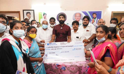 MP Margani Bharat Ram and YSRCP rural coordinator Chandana Nageswar distributing YSR Bima cheques to the beneficiaries in Rajamahendravaram on Wednesday