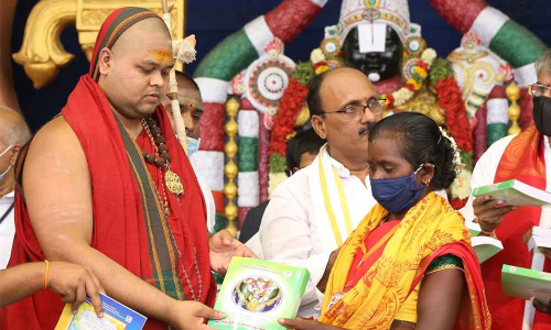 Visakha Sarada Peetham Junior Pontiff Sri Swatmanandendra Saraswathi Swami presenting a set of religious books to Dalits and tribals provided by TTD
