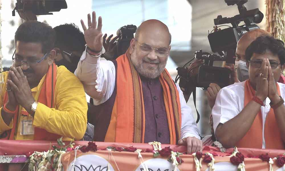 Union Home Minister Amit Shah during a roadshow in support of BJP candidates ahead of the third phase of West Bengal Assembly polls, at Baruipur Paschim in South 24 Parganas on Friday