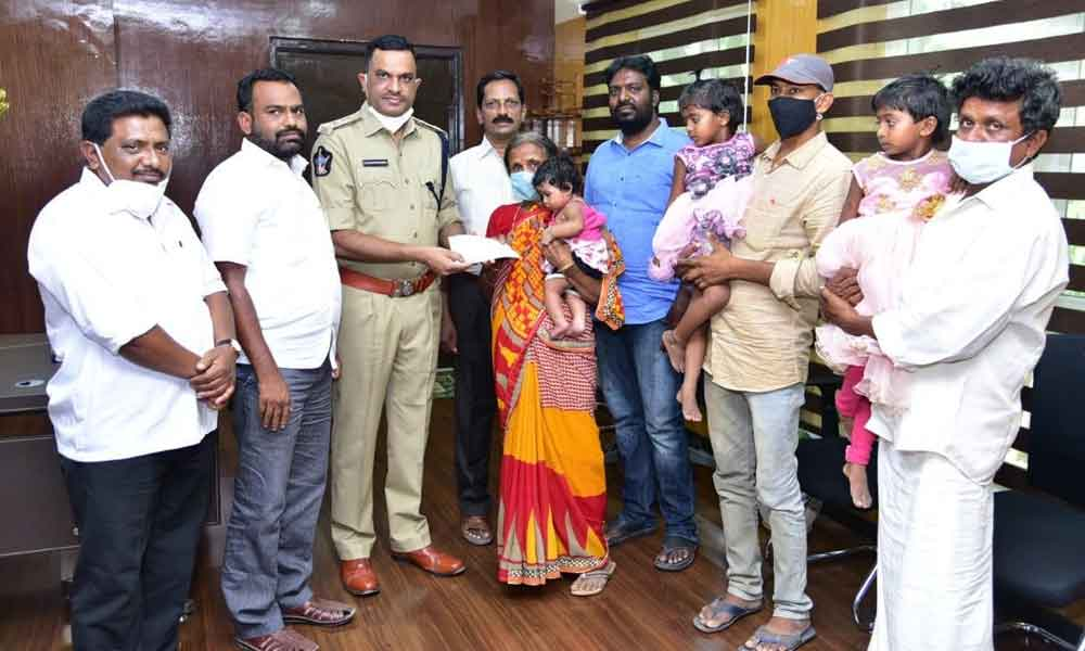 SP Fakkeerappa Kaginelli handing over the cheque to the kin of deceased family members, in Kurnool on Saturday.