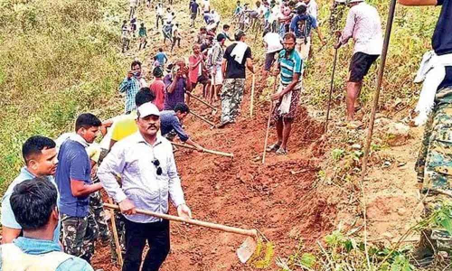 Police taking part in Shramdan to lay a road to tribal village Eguva Mengangi in Salur mandal in Vizianagaram district