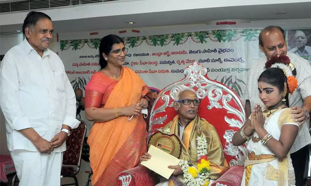 Andhra Pradesh Telugu Academy Chairperson N Lakshmi Parvathi and former Deputy Speaker Mandali Budha Prasad presenting Ugadi Puraskaram to Dr Vedantam Radhesyam in Vijayawada on Sunday