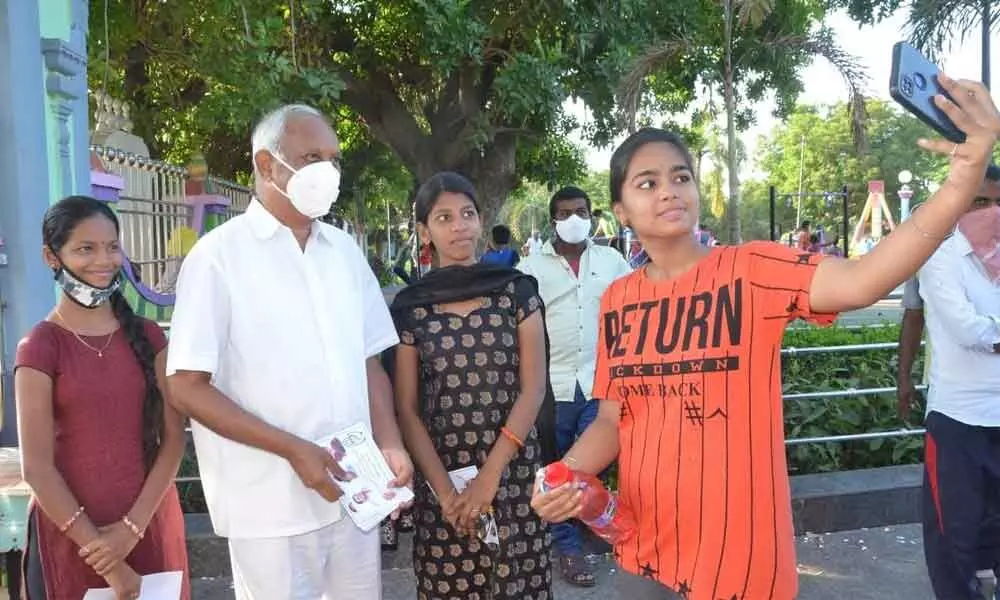 Congress candidate Dr Chinta Mohan posing for a selfie with girl in Tirupati on Sunday during his campaign