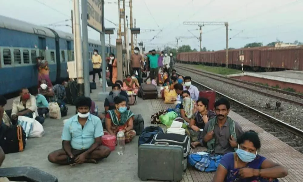 Passengers going to Odisha wait for the verification of Covid test reports and vaccine certificates by railway authorities at Amudalavalasa station