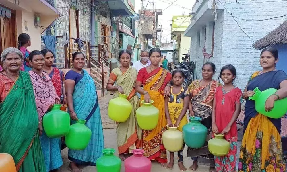 Women waiting patiently with empty plastic pots for municipal water supply at S C Colony in the first ward in Nandyal town of Kurnool district