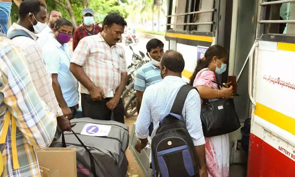 Polling personnel carry EVMs to their respective booths from SV Arts College in Tirupati on Friday