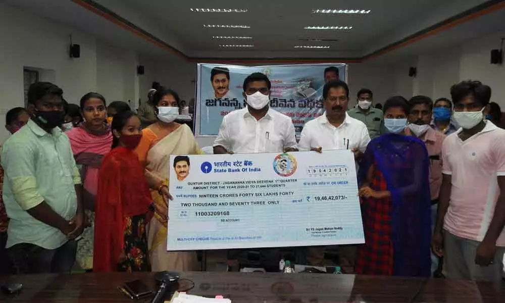 Mayor Kavati Manonar Naidu, MLA Mustafa, GMC Commissioner Challa Anuradha giving away cheques to students at a programme in Guntur on Monday