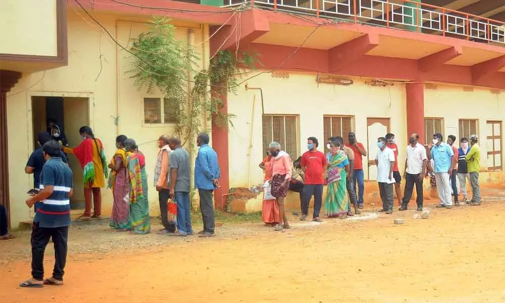 People stand in queue to undergo Covid test at the Indira Gandhi Municipal Corporation stadium in Vijayawada on Thursday