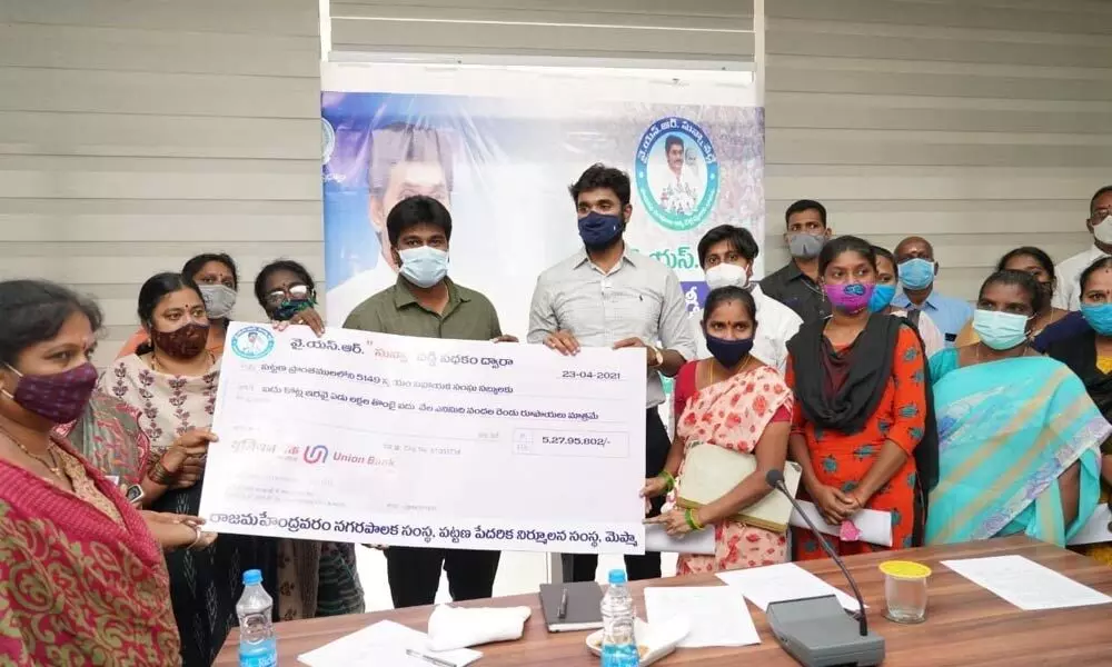 MP Bharat Ram and Commissioner Kishore distributing Dr YSR zero interest scheme cheques to beneficiaries in Rajamahendravaram on Friday