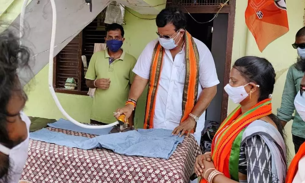 As part of election campaign BJP leader Ponguleti  Sudhakar Reddy  doing laundry works in Khammam town on Monday