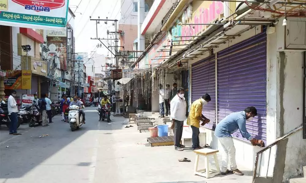 Shop owners downing shutters as per Chamber of Commerce move to prevent spread of Covid cases, in Tirupati on Tuesday