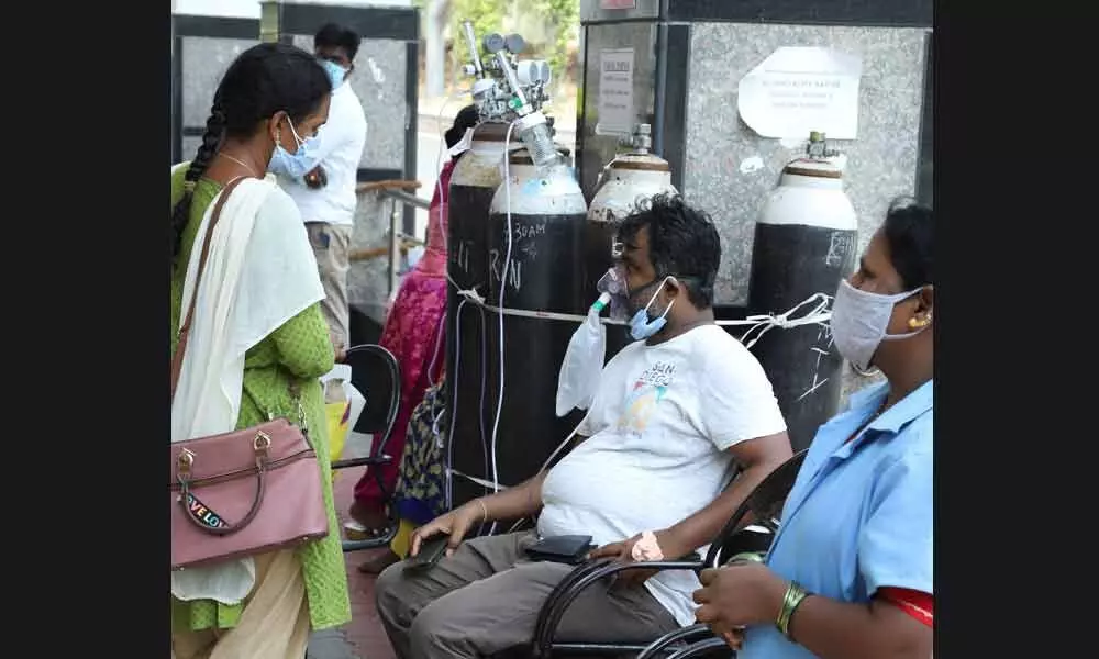 A corona positive patient with oxygen cylinder waiting at SVIMS Padmavathi hospital due to lack of beds, in Tirupati on Tuesday