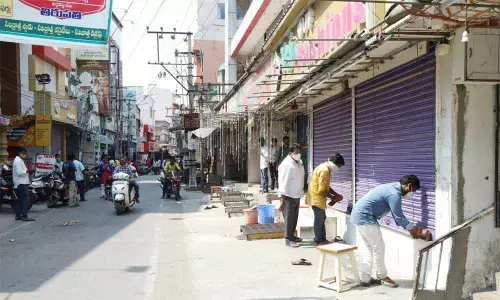 Shop owners downing shutters as per Chamber of Commerce move to prevent spread of Covid cases, in Tirupati on Tuesday