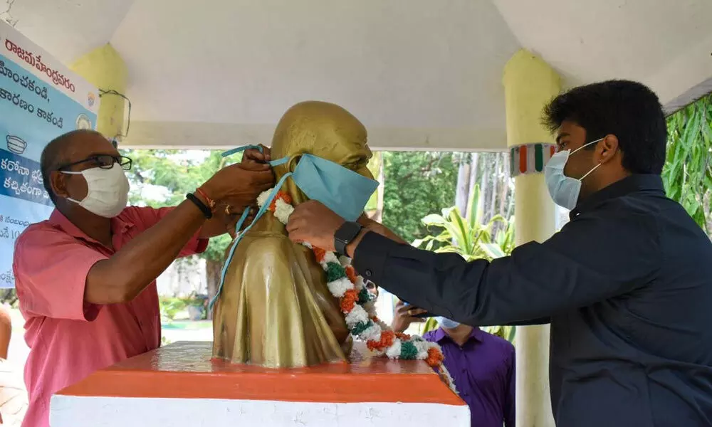 Municipal Commissioner Abishikt Kishore decorating statue of Mahatma Gandhi with a mask in Rajamahenravaram on Thursday