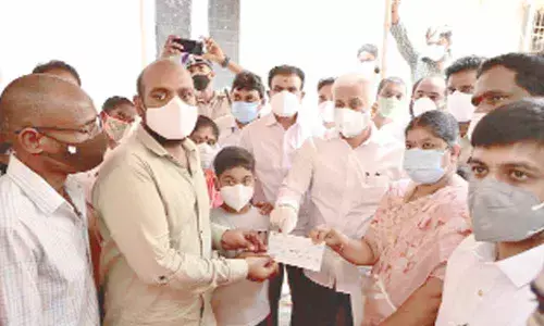 Rajya Sabha member V Vijayasai Reddy handing over a cheque for Rs 12 lakh in Visakhapatnam on Friday to the family members of victims in Juttada murder case towards compensation promised by the State government