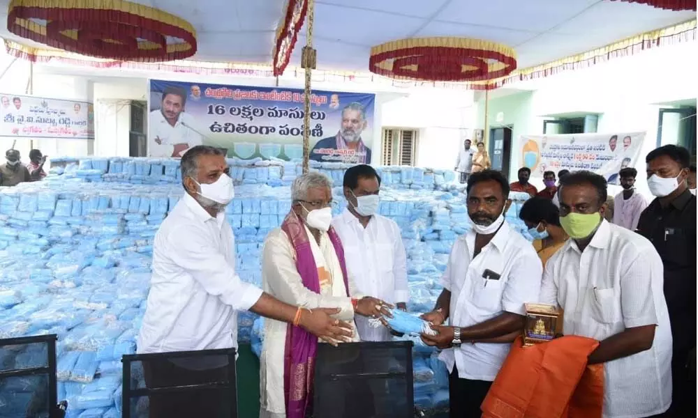 TTD chairman Y V Subba Reddy and MLA Chevireddy Bhaskar Reddy distributing face masks and hand sanitisers at MDO office in Tirupati on Saturday