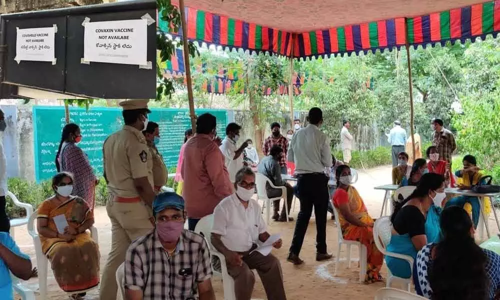 People wait at a vaccination centre in the hope of getting the shop; ‘No stock’ notice boards  displayed at Godarigunta Urban Primary Health Care Centre in Kakinada on Sunday (inset pic)
