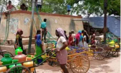Locals waiting at drinking water taps to fill their plastic  pots at Alur in Kurnool district