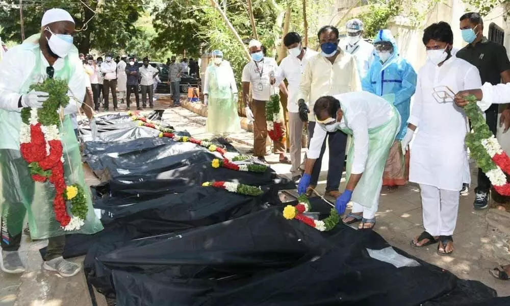 MLA B Karunakar Reddy placing a wreath on a Covid victims body as part of performing last rites, in Tirupati on Wednesday