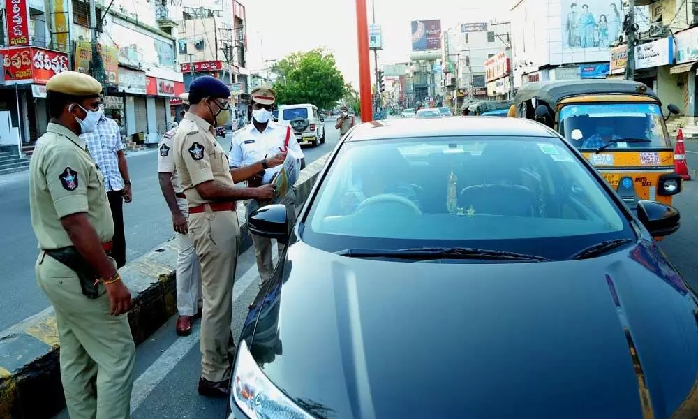 Police questioning a vehicle driver during curfew hours in Guntur on Friday