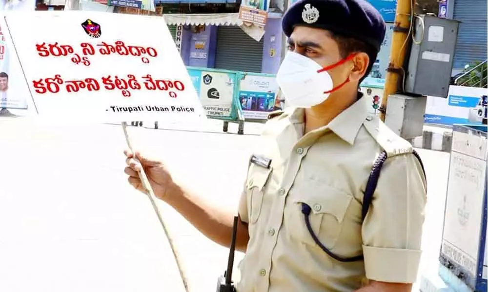 Urban SP Venkata Appala Naidu holding a placard on following curfew rules to contain Covid, inspecting a busy road in Tirupati on Sunday