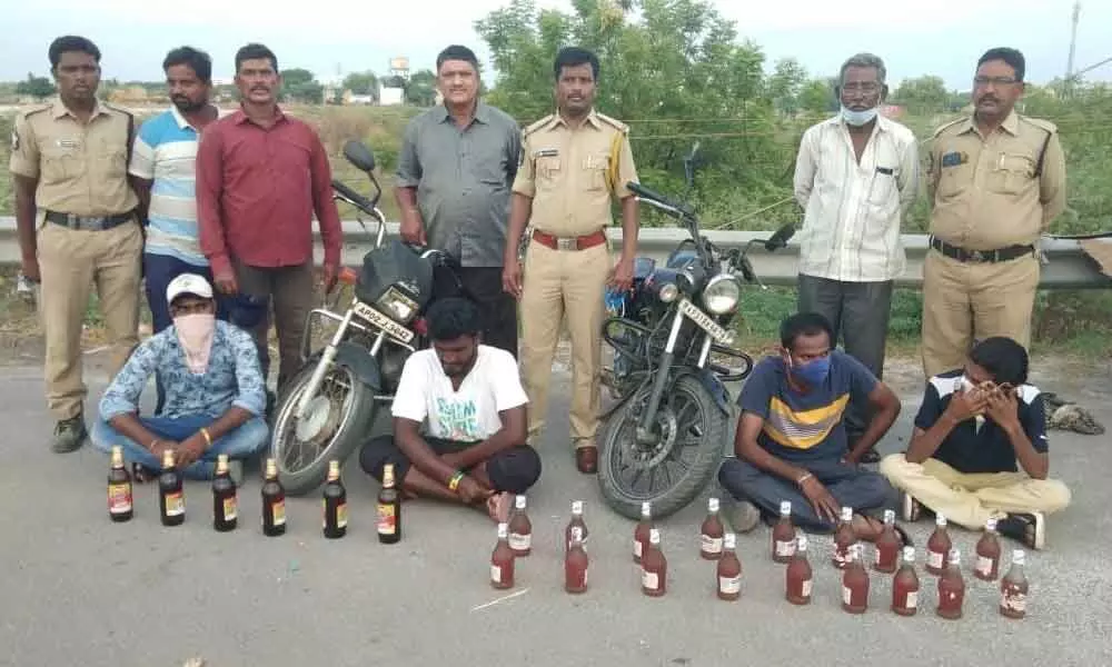 SEB Circle Inspector N Lakshmi Durgaiah and his staff with seized liquor bottles at Panchalingala border check post on Sunday