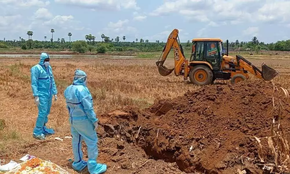 Musunuru police performing funeral of an old man died of Covid at Gopavaram village of Musunuru mandal in Krishna district on Monday