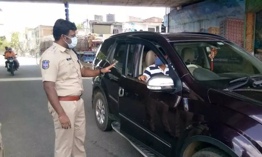 SP R Bhaskaran asking the permission letter of a commuter during lockdown in Suryapet on Saturday