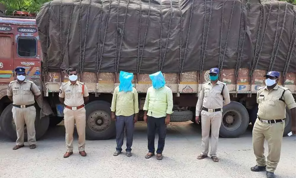 Police with seized PDS rice lorry and accused in Badvel town on Monday
