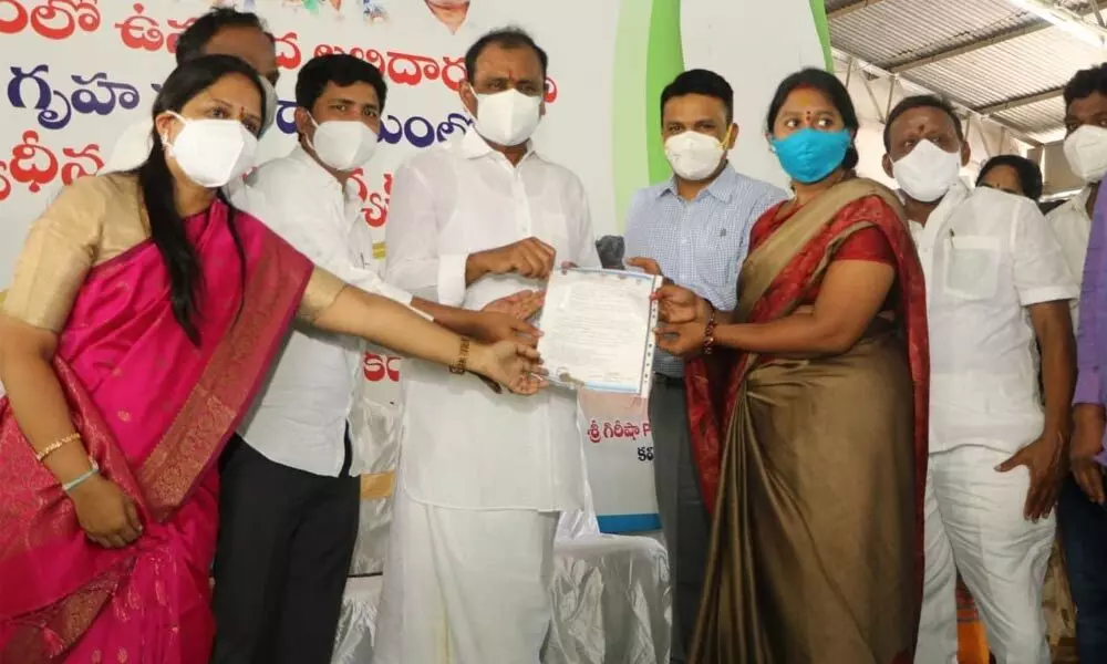 MLA B Karunakar Reddy along with Mayor Dr R Sirisha handing over the house allotment order to a beneficiary in Tirupati on Tuesday