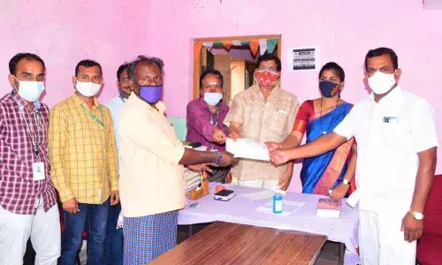 DCCB chairman Konduru Ravinder giving the cheque to  Bojja Vajravva’s husbend