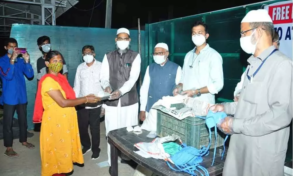 Jamaat-e-Islami district president Muhammad Khairuddin and others distributing food to the attendants of Covid patients at Karimnagar Civil Hospital on Sunday