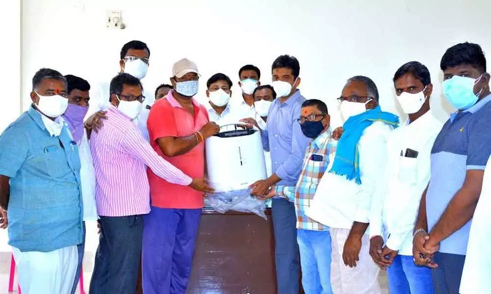 Dr Sanjay handing over the oxygen concentrators to press club president Mukkera Chandrasekha in Korutla on Sunday
